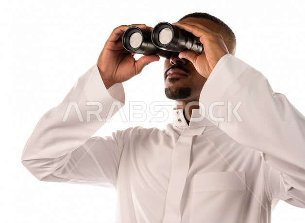 بورتريه لشاب عربي خليجي سعودي، ينظر من خلال الناظور، إيماءات وجه تدل على الدهشة والتعجب، الاستكشاف و المغامرة، فريق الكشافة، شاب اسمر، خلفية بيضاء