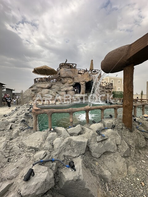 وجهة طبيعية مشهورة في المملكة العربية السعودية، تدفق شلال المياه في منتزه سمره في مدينة أبها، مناطق الرحلات الترفيهية العائلية السياحية، الاهتمام بالحدائق والطبيعة المتميزة، منظر الغيوم المتجمعة في السماء