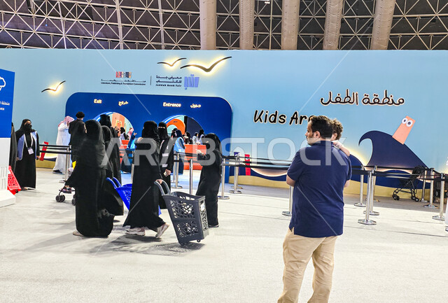 مجموعة أشخاص يتجولون امام نقطة الدخول والخروج في معرض الكتاب الدولي في جدة، المعالم والأماكن السياحية الثقافية المشهورة، استقطاب وجذب السياح من أنحاء العالم، معارض وفعاليات في المملكة العربية السعودية، قضاء أوقات ممتعة في شراء الروايات المفيدة للتعلم والتثقف