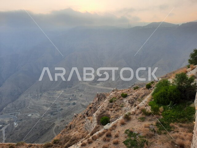 السحب والغيوم الكثيفة على القمم والمرتفعات والجبال العالية، أماكن طبيعية للمغامرات ورحلات السفاري، البيئة الجبلية لمنطقة أبها في عسير، سلاسل الجبال الصخرية، التضاريس على سفوح الجبل