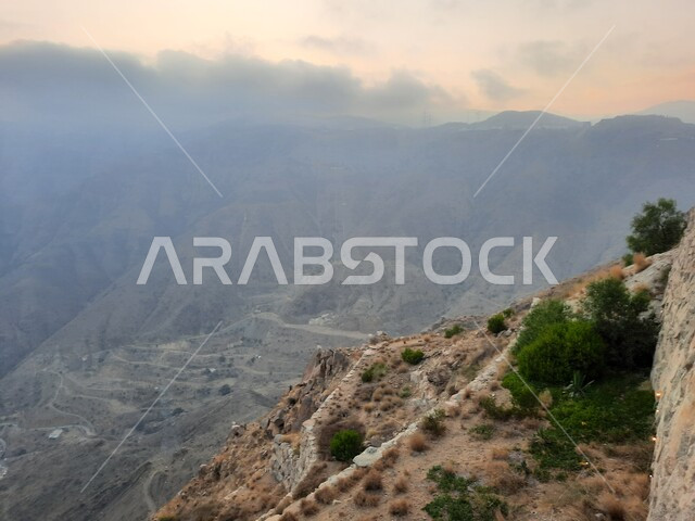 اطلالة مرتفعة متميزة على البيئة الجبلية لمنطقة أبها في عسير، الغيوم والسحب الكثيفة التي تغطي سفوح الجبل، مناطق طبيعية للمغامرات ورحلات السفاري، القمم والمرتفعات والطبيعة في المملكة العربية السعودية