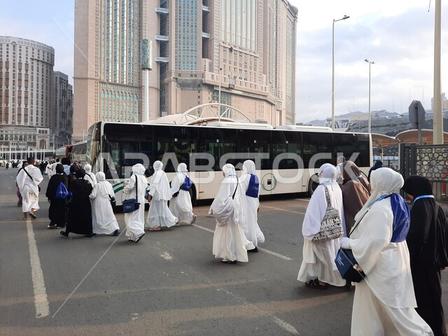 باصات نقل الحجاج والمعتمرين إلى مكة المكرمة, أداء مناسك الحج والعمرة, أماكن ومعالم دينية إسلامية مقدسة في المملكة العربية السعودية, وصول مجموعة من زوار بيت الله الحرام الى موقف الحافلات خارج المسجد الحرام، الفن الهندسي المعماري للفنادق وبرج الساعة