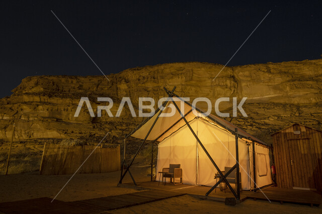 التكوينات والتشكيلات الصخرية في الصحاري، خيمة بيضاء في صحراء المملكة العربية السعودية في الليل، مغامرة ورحلة ترفيهية، التخييم في المناطق الصحراوية في محافظة العلا، جلسة وكشتة شبابية في البرية، مكان ومنطقة سياحية مشهورة