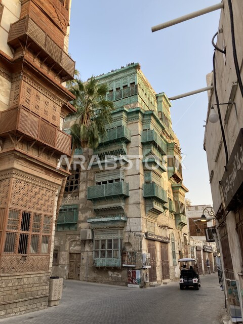 Wandering through the alleys and famous landmarks during the day, the historic buildings and houses in the historic Al-Balad district in Jeddah, the ancient Arabic architectural style, the old windows in the historic city in the Kingdom of Saudi Arabia, a popular heritage tourist place and area