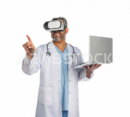 Portrait of a Saudi Gulf doctor wearing virtual reality (VR) 3D glasses, using a laptop to accomplish tasks, the concept of medicine and health care, medical professions and jobs, using modern technical devices, using the sense of touch to move holographi