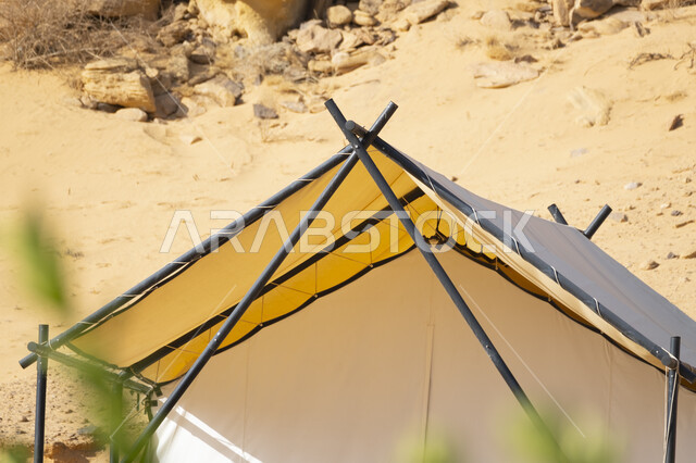 كشتة وجلسة شبابية في البرية، التخييم في المناطق الصحراوية في محافظة العلا، مكان ومنطقة سياحية مشهورة في صحراء المملكة العربية السعودية، مغامرة ورحلة ترفيهية، خيمة بيضاء على الرمال الذهبية الناعمة، التكوينات والتشكيلات الصخرية في الصحاري