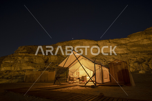 A famous tourist place and area, rock formations and formations in the deserts, a white tent in the desert of the Kingdom of Saudi Arabia at night, an adventure and a recreational trip, camping in the desert areas of Al-Ula Governorate, a youth session and outing in the wilderness