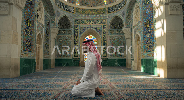 الديكور الداخلي للأقواس والأعمدة الداخلية على الطراز الإسلامي، الأجواء الروحانية الدينية في بيت الله، مفهوم الدعاء والتضرع والترجي، الاجتهاد في العباده والطاعة، رجل عربي خليجي سعودي  يرتدي الثوب التقليدي والشماغ يصلي داخل المسجد، التوبة والرجوع إلى الله