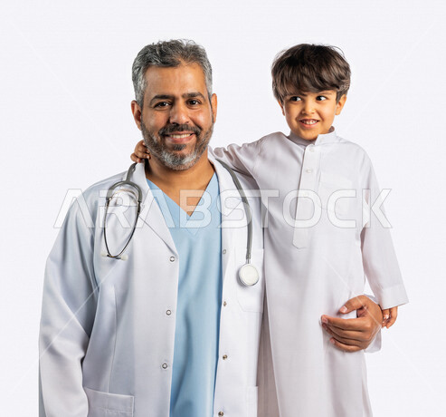بورتريه لطبيب خليجي سعودي مع طفل صغير ، ينظران إلى الكاميرا ، مفهوم الطب والرعاية الصحية ، الفحص الطبي للأطفال ، تقديم الرعاية والخدمات الصحية ، مهن ووظائف طبية ، موعد مع الطبيب لتلقي العلاج
