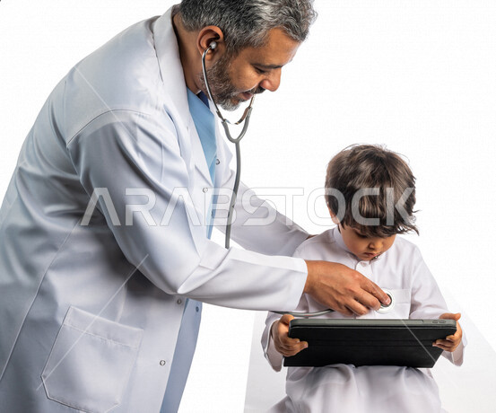بورتريه لطبيب خليجي سعودي مع طفل صغير ، إستخدام جهاز التابلت ، مفهوم الطب والرعاية الصحية ، الفحص الطبي للأطفال ، تقديم الرعاية والخدمات الصحية ، مهن ووظائف طبية ، يفحص الطبيب قلب الطفل عبر سماعة الأذن ، موعد مع الطبيب لتلقي العلاج