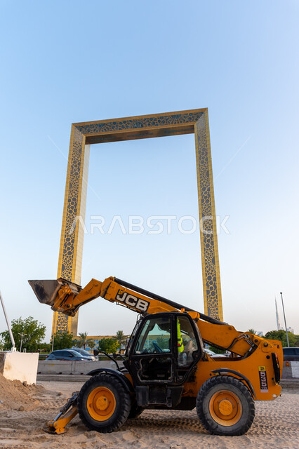 A bulldozer transporting sand and gravel, distinctive modern architectural art and design, famous landmarks and tourist places in the United Arab Emirates, attracting and attracting tourists from all over the world, Dubai Frame in Dubai during the day