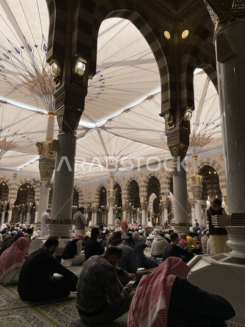  العبادة والتقرب الى الله، الأعمدة والأقواس بديكور وتصميم داخلي مميز على الطراز الاسلامي، جلوس المسلمين تحت المظلات الالكترونية داخل المسجد النبوي الشريف، تجمع المصلين في ساحات الحرم النبوي في المدينه المنوره لأداء الصلاة، أماكن ومعالم دينية مقدسة في السعودية
