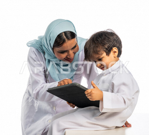 بورتريه لطبيبة خليجية سعودية مع طفل صغير ، إستخدام جهاز التابلت ، مفهوم الطب والرعاية الصحية ، الفحص الطبي للأطفال ، تقديم الرعاية والخدمات الصحية ، مهن ووظائف طبية  ، موعد مع الطبيب لتلقي العلاج ، مفهوم إستخدام التكنولوجيا وأجهزة تقنية حديثة