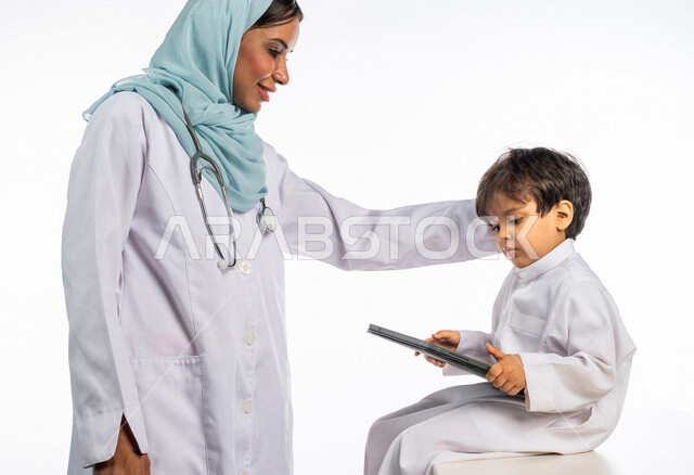 بورتريه لطبيبة خليجية سعودية مع طفل صغير ، إستخدام جهاز التابلت ، مفهوم الطب والرعاية الصحية ، الفحص الطبي للأطفال ، تقديم الرعاية والخدمات الصحية ، مهن ووظائف طبية  ، موعد مع الطبيب لتلقي العلاج ، مفهوم إستخدام التكنولوجيا وأجهزة تقنية حديثة