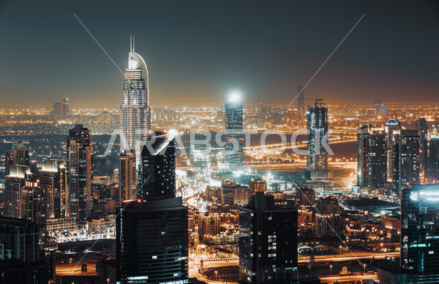 المباني والمنشآت المضيئة في الليل بمدينة دبي, الفن الهندسي المعماري لبناء الأبراج وناطحات السحاب على الطراز الحديث, مفهوم التقدم والتطور العمراني, مكان سياحي مشهور في الإمارات العربية المتحدة, جذب واستقطاب السياح من أنحاء العالم