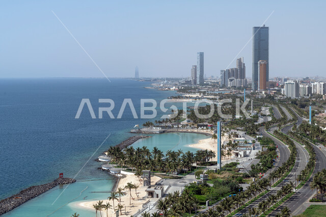 الواجهة البحرية لكورنيش مدينة جدة في المملكة العربية السعودية، أمواج البحر الهادئة على شواطئ الكورنيش، الفن الهندسي المعماري للأبراج وناطحات السحاب، الأشجار والنباتات الخضراء المحيطة بالطرق والشوارع العامة، معالم جدة المشهورة، أماكن سياحية في السعودية