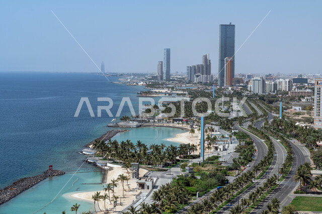 الواجهة البحرية لكورنيش مدينة جدة في المملكة العربية السعودية، أمواج البحر الهادئة على شواطئ الكورنيش، الفن الهندسي المعماري للأبراج وناطحات السحاب، الأشجار والنباتات الخضراء المحيطة بالطرق والشوارع العامة، معالم جدة المشهورة، أماكن سياحية في السعودية