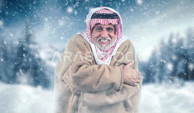 صورة لرجل عربي سعودي كبير بالسن يشعر بشدة البرد وألم العظام , خلفية لتساقط الثلج , ايماءات وجه ويدين تدل على التعب الشديد من البرد , أجواء ثلجية قطبية.