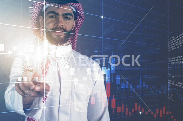 صورة مقربة لرجل عربي خليجي سعودي أمام شاشة رقمية ، يضغط بأصبعه بتقنية الهولوجرام ، البورصة و الأسهم المالية  ، خاصية الهولجرام ثلاثية الأبعاد ، رموز رقمية الكترونية