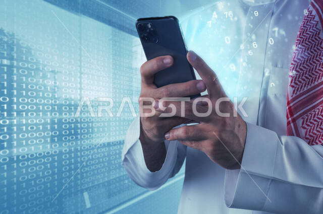 A close-up image of a Saudi Arabian Gulf man standing next to a screen containing a programming language and holding a mobile phone in his hand with a group of luminous flying numbers coming out using hologram technology, using 3D hologram technology