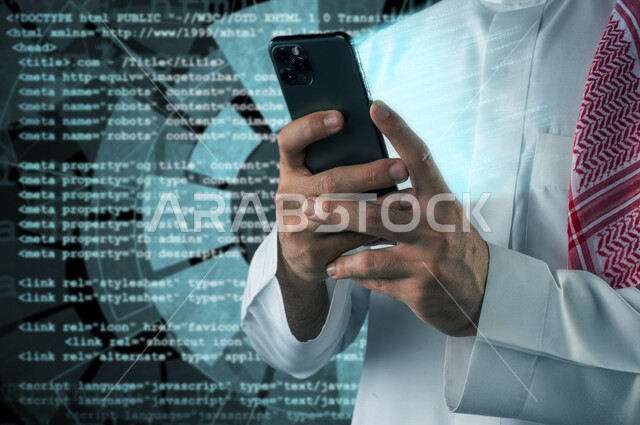 صورة مقربة لرجل عربي خليجي سعودي يقف بجانب شاشة تحتوي لغة الخاصة بالبرمجة و يمسك بيده هاتف محمول مع خروج مجموعة من الأرقام المضيئة المتطايرة بتقنية الهولوجرام ، استخدام تقنية الهولوجرام ثلاثية الأبعاد