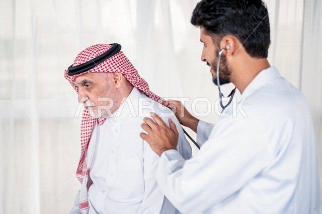 طبيب باطنية عربي سعودي خليجي يقوم بتقديم الرعاية الصحية المناسبة لمريض كبير بالسن في المستشفى , يقوم الطبيب بسماع دقات قلب المريض للتأكد من سلامة المريض , مفهوم الطب والرعاية الصحية .