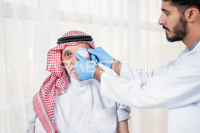 طبيب عيون مختص عربي سعودي خليجي يقوم بتقديم الرعاية الصحية المناسبة لمريض كبير بالسن في المستشفى , يقوم الطبيب بتغطية عين المريض لتحسين نظر العين الأخرى للمريض , مفهوم الطب والرعاية الصحية .