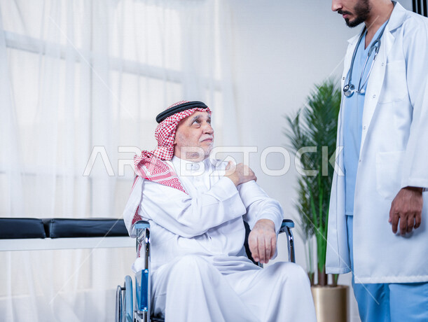 مريض عربي سعودي كبير بالسن يشكو من آلام في الكتف واليد , يقوم الطبيب بفحص المريض والتأكد من سلامة اليد , صحة وأطباء , حالة مرضية , مهن ووظائف طبية , خلفية بيضاء .