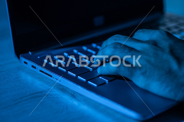 صورة مقربة ليد رجل عربي خليجي سعودي يستخدم الحاسوب المحمول ،الكتابة من خلال لوحة المفاتيح ، ادخال البيانات، صناعة المحتويات النصية،التسويق والترويج للمواقع الالكترونية، القيام بالاعمال الادارية ،التعليم الالكتروني