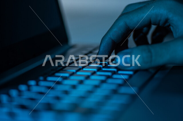 صورة مقربة ليد رجل عربي خليجي سعودي يستخدم الحاسوب المحمول ،الكتابة من خلال لوحة المفاتيح ، ادخال البيانات، صناعة المحتويات النصية،التسويق والترويج للمواقع الالكترونية، القيام بالاعمال الادارية ،التعليم الالكتروني