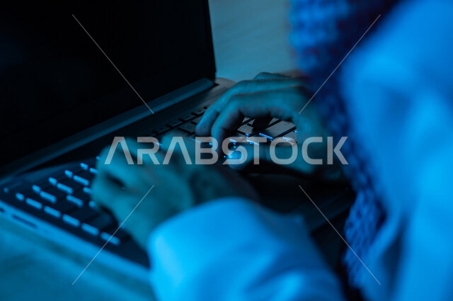 صورة مقربة ليد رجل عربي خليجي سعودي يستخدم الحاسوب المحمول ،الكتابة من خلال لوحة المفاتيح ، ادخال البيانات، صناعة المحتويات النصية،التسويق والترويج للمواقع الالكترونية، القيام بالاعمال الادارية ،التعليم الالكتروني