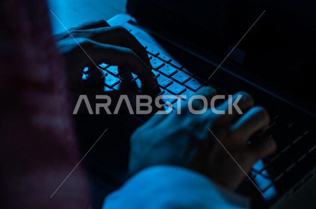 صورة مقربة ليد رجل عربي خليجي سعودي يستخدم الحاسوب المحمول ،الكتابة من خلال لوحة المفاتيح ، ادخال البيانات، صناعة المحتويات النصية،التسويق والترويج للمواقع الالكترونية، القيام بالاعمال الادارية ،التعليم الالكتروني