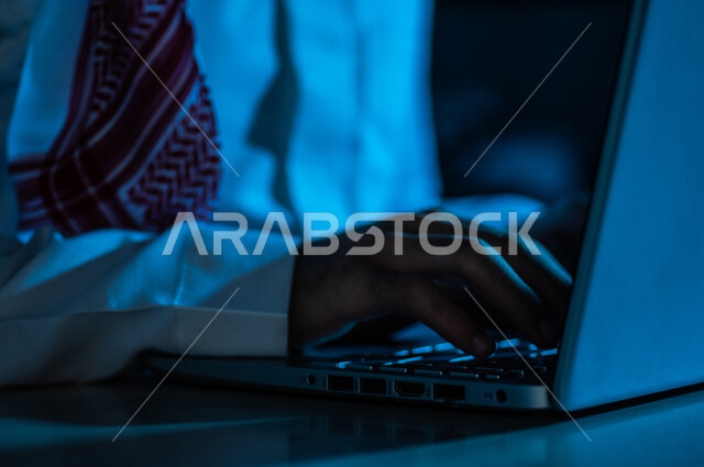 صورة مقربة ليد رجل عربي خليجي سعودي يستخدم الحاسوب المحمول ،الكتابة من خلال لوحة المفاتيح ، ادخال البيانات، صناعة المحتويات النصية،التسويق والترويج للمواقع الالكترونية، القيام بالاعمال الادارية ،التعليم الالكتروني