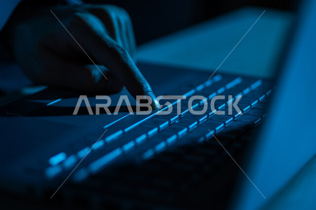 صورة مقربة ليد رجل عربي خليجي سعودي يستخدم الحاسوب المحمول ،الكتابة من خلال لوحة المفاتيح ، ادخال البيانات، صناعة المحتويات النصية،التسويق والترويج للمواقع الالكترونية، القيام بالاعمال الادارية ،التعليم الالكتروني