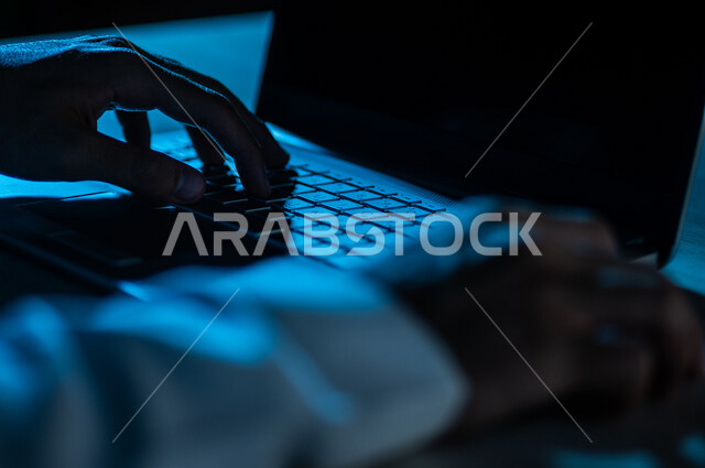 صورة مقربة ليد رجل عربي خليجي سعودي يستخدم الحاسوب المحمول ،يستخدم الفأرة والكتابة من خلال لوحة المفاتيح ، ادخال البيانات، صناعة المحتويات النصية ،التسويق والترويج للمواقع الالكترونية، القيام بالاعمال الادارية ،التعليم الالكتروني