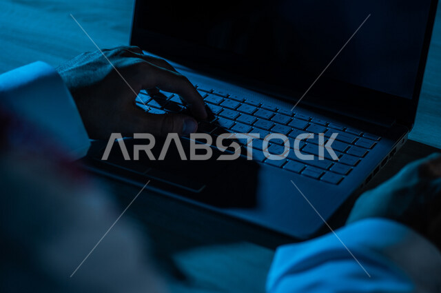 صورة مقربة ليد رجل عربي خليجي سعودي يستخدم الحاسوب المحمول ،الكتابة من خلال لوحة المفاتيح ، ادخال البيانات، صناعة المحتويات النصية،التسويق والترويج للمواقع الالكترونية، القيام بالاعمال الادارية ،التعليم الالكتروني