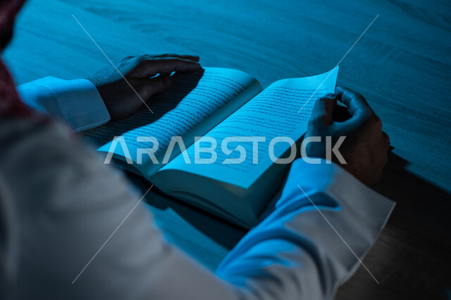 صورة مقربة لرجل عربي خليجي سعودي يقرا الكتاب ، باحث علمي ،كتاب جامعي ، قصص وروايات  ،اكتساب المعرفة ، تعليم وثقافة