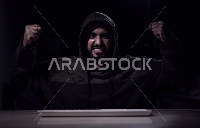 شاب عربي خليجي سعودي بايماءات وجه سعيدة، يعمل في مجال الهكر الغير قانوني، اختراق حماية وأمن وخصوصية المستخدمين، الجرائم الالكترونية