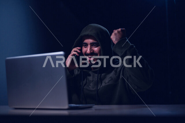 شاب عربي خليجي سعودي بايماءات وجه سعيدة، يعمل في مجال الهكر الغير قانوني، اختراق حماية وأمن وخصوصية المستخدمين، التنصت على المكالمات، اختراق المكالمات الصوتية وخصوصية المستخدم، الجرائم الالكترونية