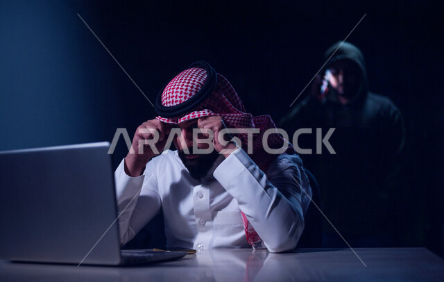 رجل عربي خليجي سعودي بايماءات وجه حزينة، التعرض للإختراق والهجمات الالكترونية، الاختراق الأمني، اختراق حماية وأمن وخصوصية المستخدمين، الجرائم الالكترونية