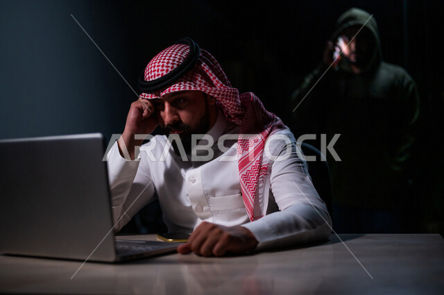 رجل عربي خليجي سعودي بايماءات وجه حزينة، التعرض للإختراق والهجمات الالكترونية، الاختراق الأمني، اختراق حماية وأمن وخصوصية المستخدمين، الجرائم الالكترونية
