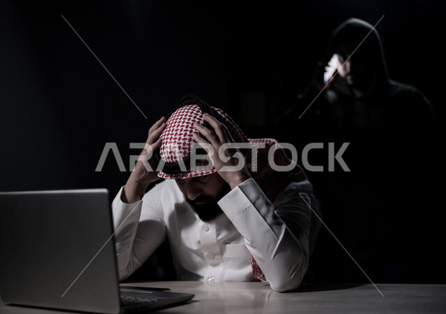 رجل عربي خليجي سعودي بايماءات وجه حزينة، التعرض للإختراق والهجمات الالكترونية، الاختراق الأمني، اختراق حماية وأمن وخصوصية المستخدمين، الجرائم الالكترونية