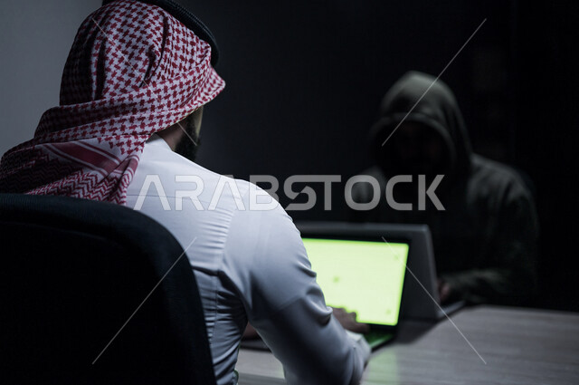 رجل عربي خليجي سعودي يستخدم حاسوبه المحمول، التعرض للإختراق والهجمات الالكترونية، الاختراق الأمني، اختراق حماية وأمن وخصوصية المستخدمين، الجرائم الالكترونية