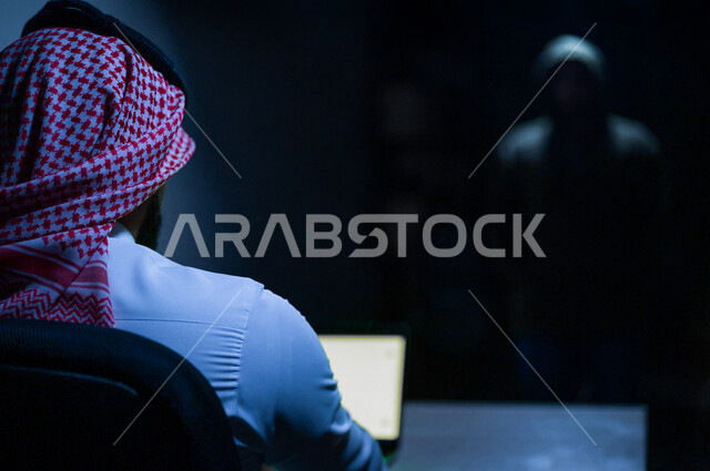 رجل عربي خليجي سعودي يستخدم حاسوبه المحمول، التعرض للإختراق والهجمات الالكترونية، الاختراق الأمني، اختراق حماية وأمن وخصوصية المستخدمين، الجرائم الالكترونية
