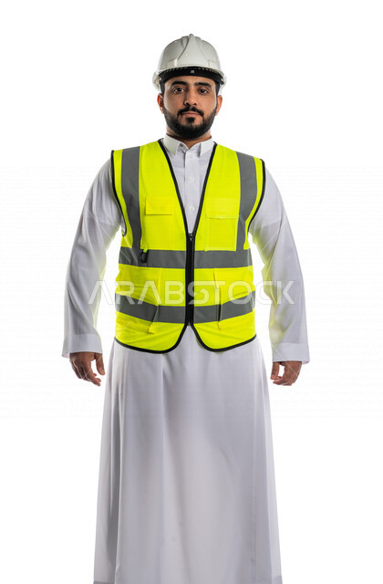 بورتريه لمهندس عربي خليجي سعودي يرتدي الخوذة والسترة الخاصة بالعمل ، مهندس معماري محترف ينظر الى الكاميرا، مهن و وظائف هندسية ،خلفية بيضاء