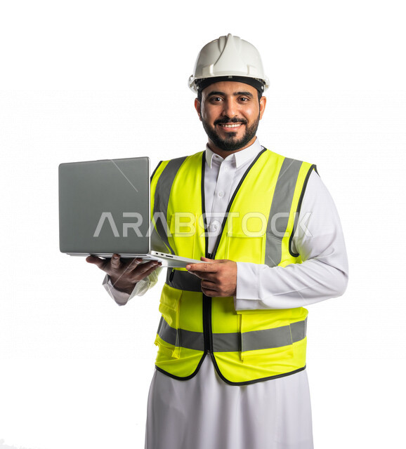 بورتريه لمهندس عربي خليجي سعودي يرتدي قبعة و سترة الوقاية ، يستخدم جهاز الحاسوب المحمول ،رسم المخططات من خلال البرامج الهندسية، متابعة الاعمال والمشاريع ، خلفية بيضاء