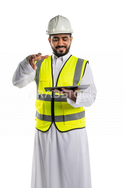 بورتريه لمهندس عربي خليجي سعودي يرتدي الخوذة والسترة الخاصة بالعمل ، يستخدم جهاز التابلت اثناء العمل ،اجراء مكالمة فيديو،شرح مخطط العمل ، مناقشة المشاريع ،خلفية بيضاء