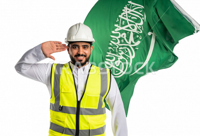 بورتريه لمهندس عربي خليجي سعودي يرتدي قبعة و سترة الوقاية ، ايماءة اليد تدل على الفخر والاعتزاز بالوطن ، خلفه علم المملكة العربية السعودية ، الاحتفال باليوم الوطني السعودي ،العيد الوطني السعودي ، خلفية بيضاء