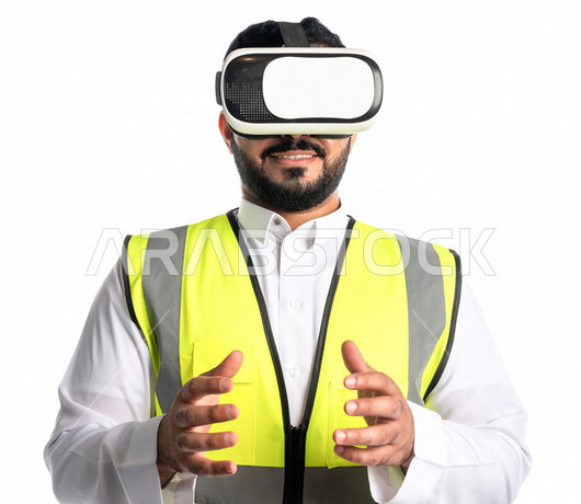 بورتريه لمهندس عربي خليجي سعودي يرتدي سترة خاصة بالعمل و نظارة الواقع الافتراضي ،يضع شيء بين يديه، التحكم في عناصر الواقع الافتراضي ثلاثي الابعاد ، تقنية الواقع الافتراضي في الهندسة المعمارية، خلفية بيضاء