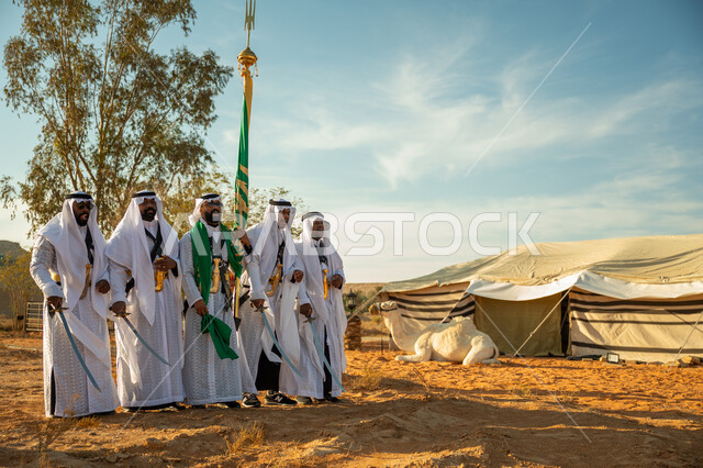 يوم بدينا ٢٢ فبراير، فرقة عروض الفلكلور التراثي في صحراء المملكة، الاحتفال باليوم الوطني بالرقص بالسيوف وقرع الطبول، ارتداء زي العرضة النجدية الشعبية في المناسبة الوطنية، جمل يجلس امام الخيمة، مفهوم حب الوطن والانتماء اليه، ذكرى تاسيس الدوله السعوديه الاولى ١٧٢٧ م